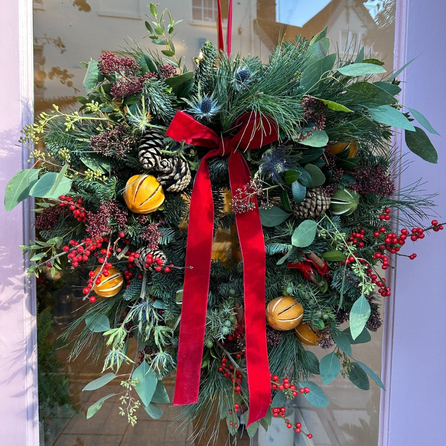 Classic Christmas Wreath. Red Velvet Ribbon, whole Oranges, fir cones, Red Ilex Berries, Scottish blue Thistle, blue spruce.