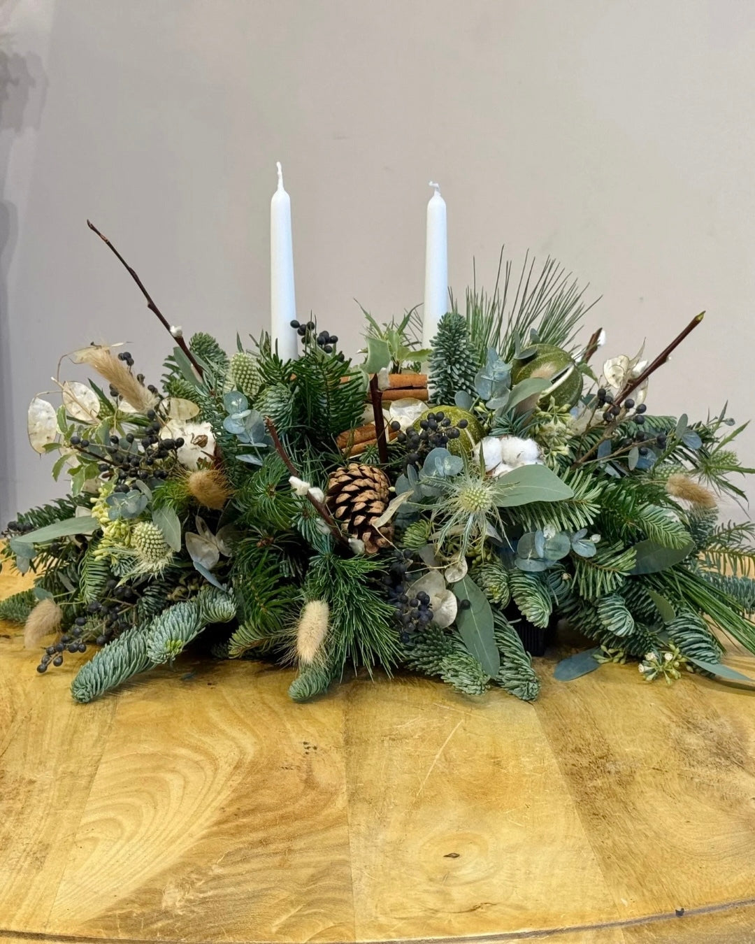 White Christmas Table Arrangement. Christmas Spruces, Thistle, Honesty, Liburnum berries, pine cones, natural bunnies tails and more.